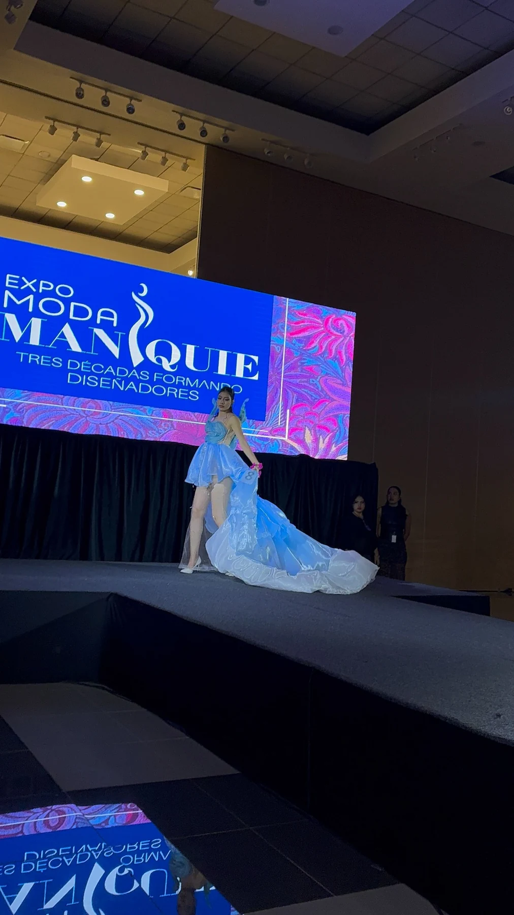 Presentación de un vestido azul de cauda larga en EXPO MANIQUIE.